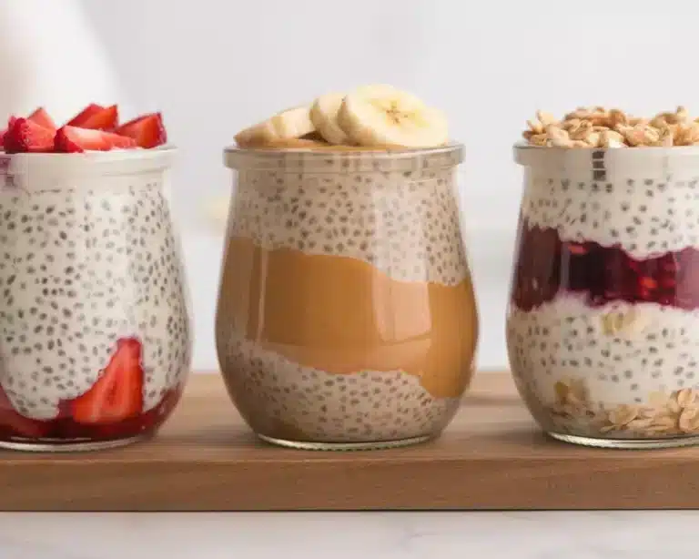 High protein overnight oats for weight loss in jars topped with strawberries, banana, and granola